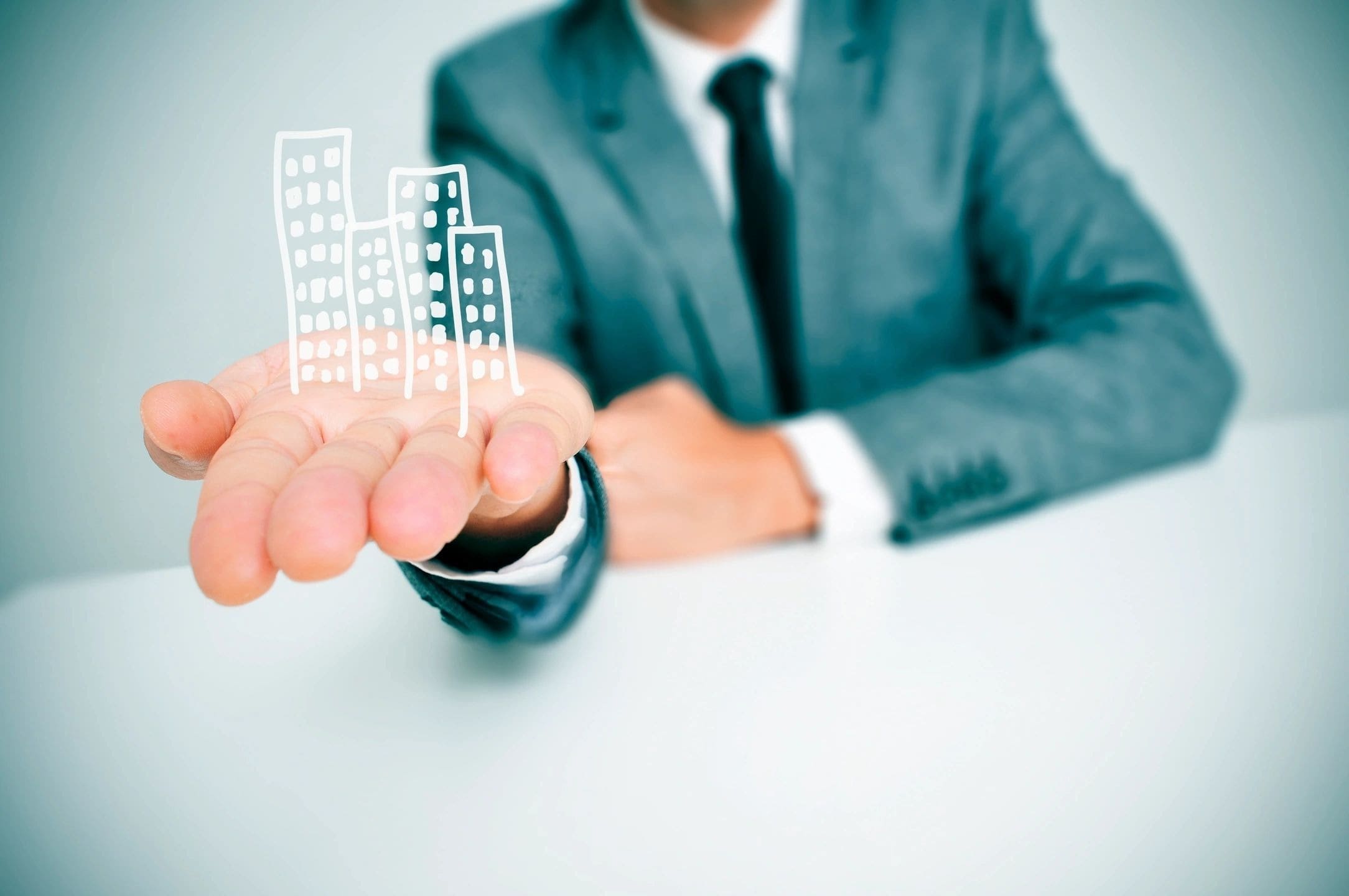 A man in a suit holding up some buildings