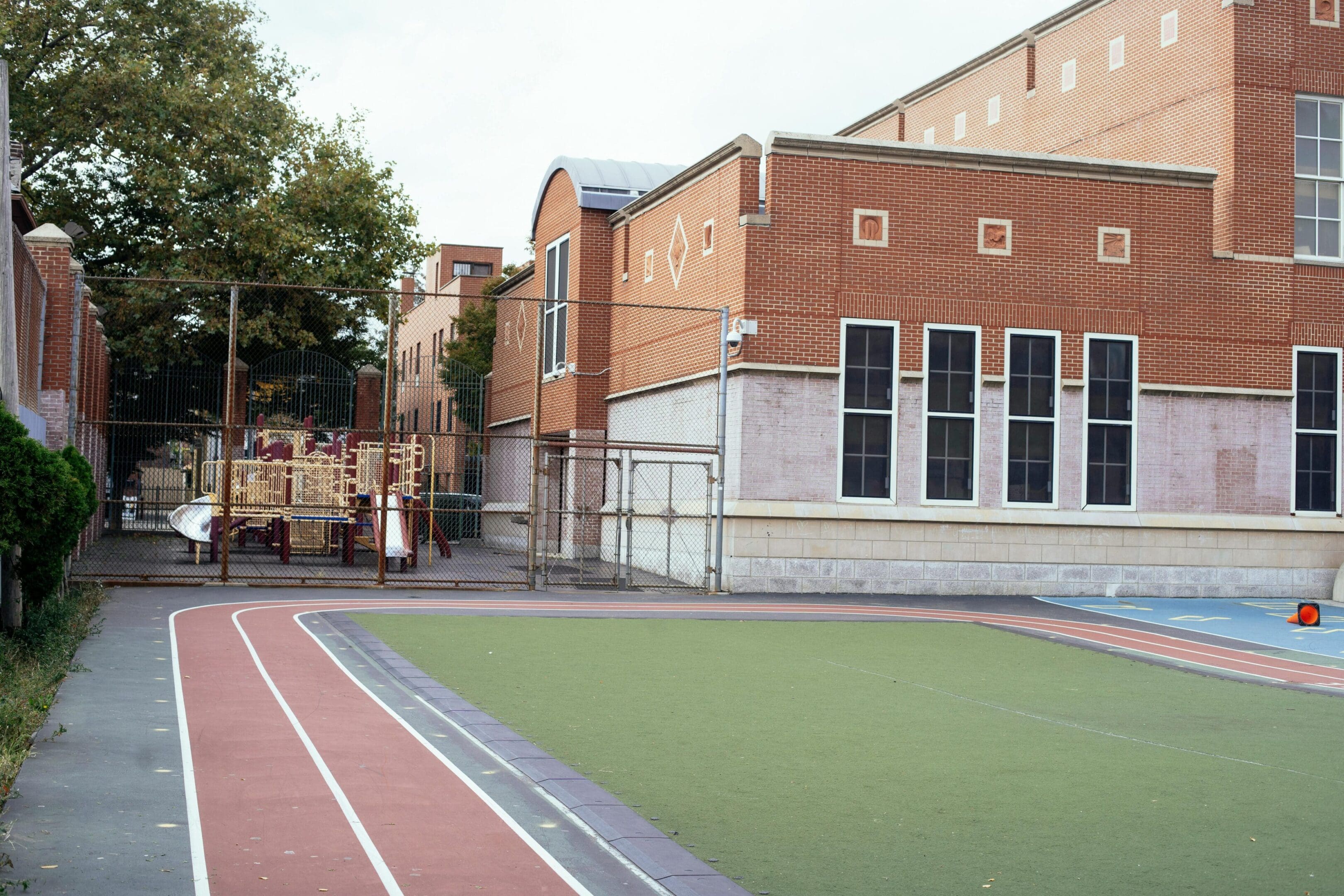 A tennis court in front of an old building.